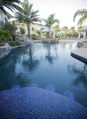 a swimming pool with blue tiles and a lazy river